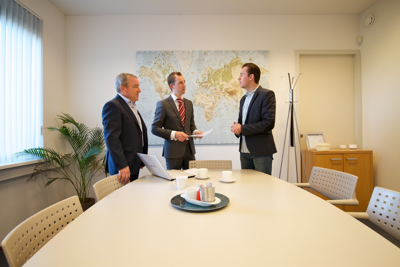 Paul Ikink, eigenaar van Administratiekantoor Ikink, bespreekt financiële zaken met twee klanten op kantoor.